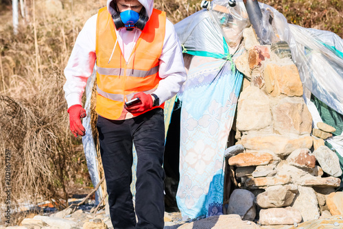 Photos Worker checking phone near improvised shelter