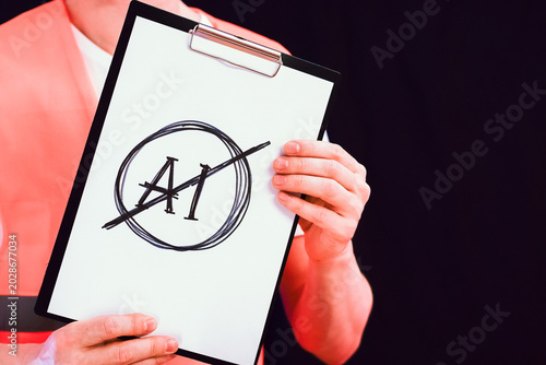 Hand displaying crossed-out AI symbol on clipboard