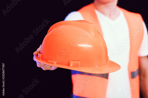 Man presenting orange construction helmet