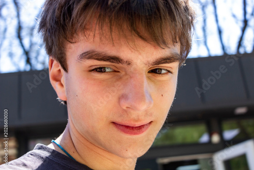 Fotografía portrait of a dark-haired teenage boy on the street in the city, smiling face, h