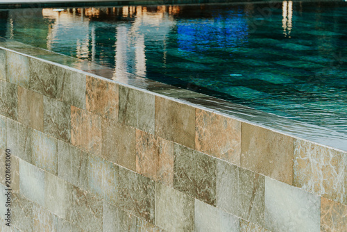 Infinity Pool Edge Overflowing Water Tiled Wall Modern Design Luxury Resort Spa Concept