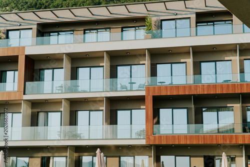 Modern Hotel Building Facade With Balconies Glass Railings And Wooden Accents