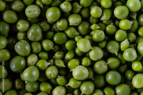 Close-up view of fresh green peas filling the frame. Natural green vegetable texture, suitable as a healthy food, ingredient or organic produce background.
