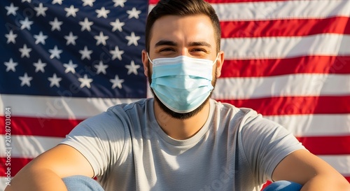Young man wearing face mask in front of American flag outdoors during pandemic