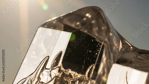 Crystal clear ice block shimmering in sunlight with sparkling details  