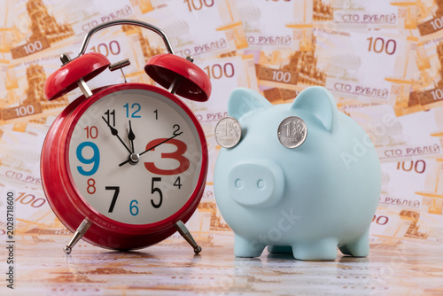 Konstfotografi A piggy bank with one ruble coins instead of eyes against a background of 100 ru