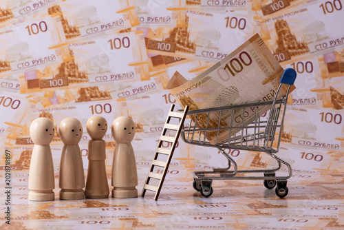 Foto A line of symbolic wooden figures stands against a backdrop of 100-ruble Russian banknotes