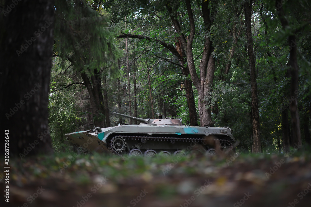 Fototapeta premium A selective focus shot of an abandoned military tank in the forest