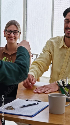 Realtor giving house keys to young couple after signing contract