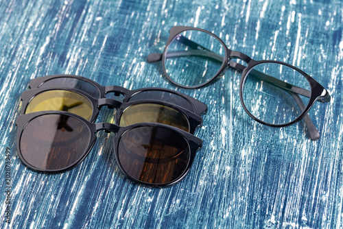 Foto Stylish Eyewear Collection With Reflective Polarized Clip On Lenses On Blue Wood