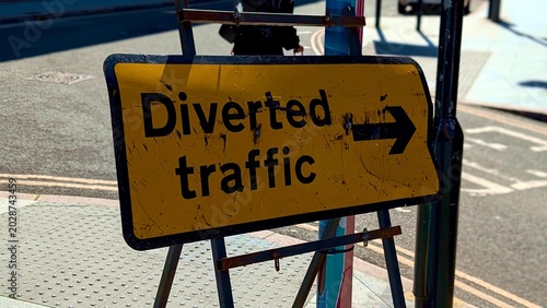 Tableau sur toile Diverted traffic sign on street, yellow roadwork diversion board with arrow on t