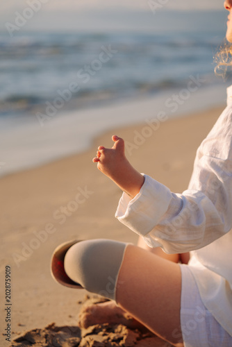 Fényképezés Woman with hand malformation meditating on beach