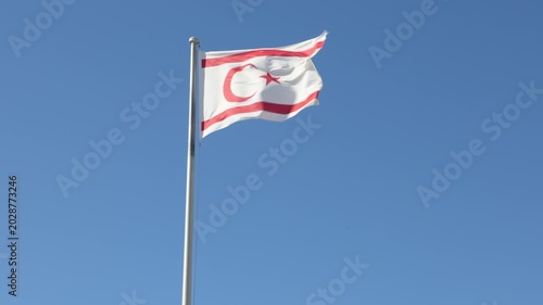 Turkish Republic of Northern Cyprus Flag waving in blue sky. Northern Cyprus.