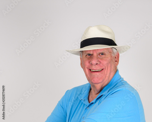 Person in blue shirt and white Panama hat with black band