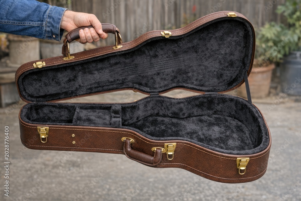 Obraz premium A person holding a guitar case, ready to play or store the instrument