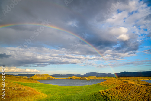 Rainbow arching over pseudocraters and lake