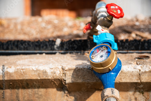 Fotografi Close-up of a domestic water meter gauge with valve handle on a residential cons
