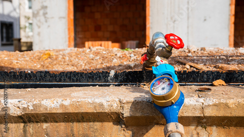 Quadro su tela Close-up of a domestic water meter gauge with valve handle on a residential cons