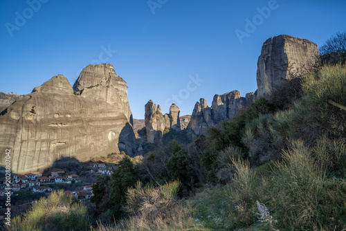 Meteora Greece rocky landscape with village and rock formations under clear sky