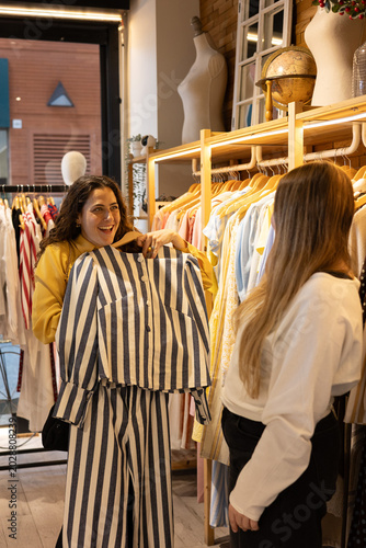 Quadro su tela Girl friends shopping for new clothes in boutique