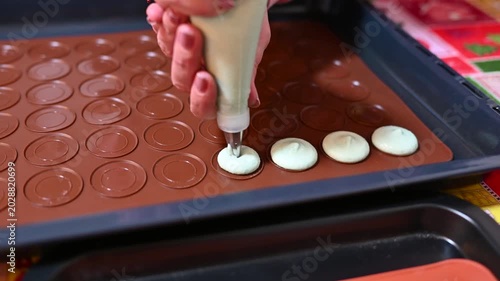 Preparing homemade french macarons. Piping batter with a pastry bag fitted with a round tip