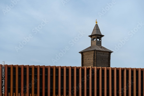 Foto Wooden Watchtower Seen Behind Fence, Vertical Metal Slats In Foreground, Lone Sp