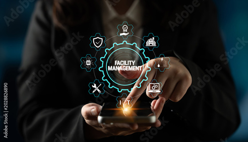 Cuadro en lienzo Professional Woman Using Smartphone for Facility Management with Digital Interface Displaying Various Icons and Symbols in Business Context Fluxor