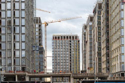 Fotografía Massive Urban Construction Site With Cranes, Concrete Frames And Scaffolding Cen