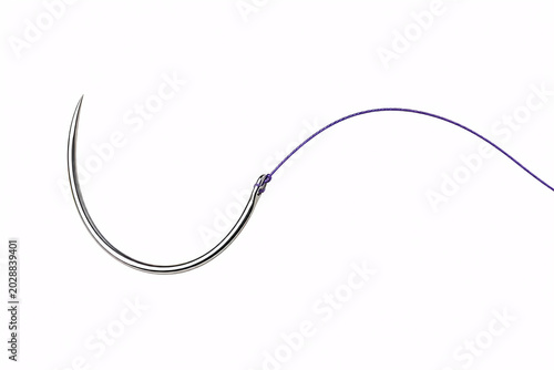 Curved surgical suture needle with purple thread isolated on a white background.