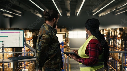 Photography Army logistics team in uniform working in warehouse on military base, coordinating pallets distribution