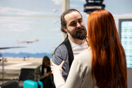 Canvas Print Boyfriend and girlfriend reuniting in airport terminal with joyful emotions, hugging and smiling after arrival
