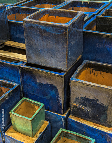 Garden planters painted with blue ceramic glaze and featuring a glossy finish