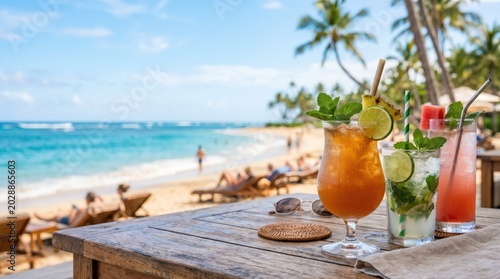 Three tropical drinks on wooden beach table with ocean background