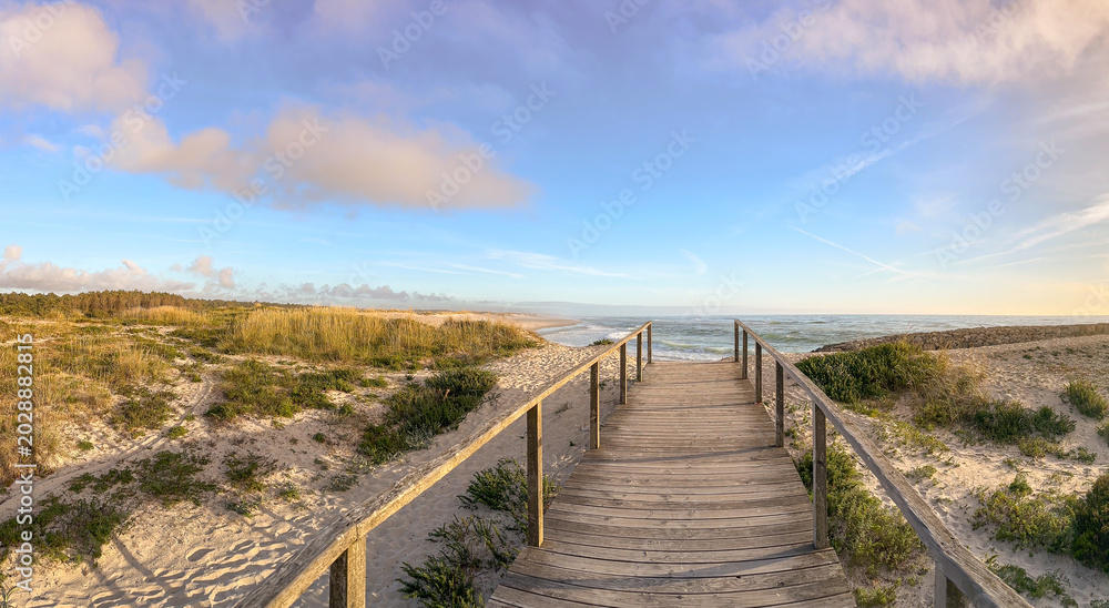 Fototapeta premium Wooden Boardwalk Leading to the Atlantic Coast at Furadouro Beach in Ovar Portugal