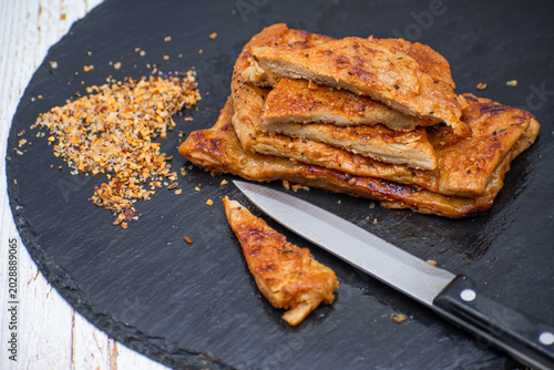 Vegan seitan schnitzel slices on slate plate, cut steak style