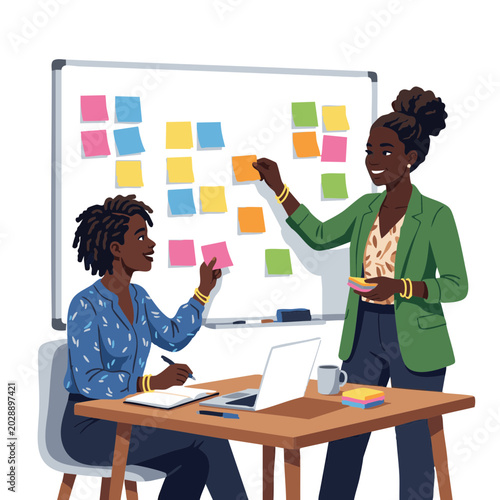 Two Black women brainstorming and collaborating at a table in office  