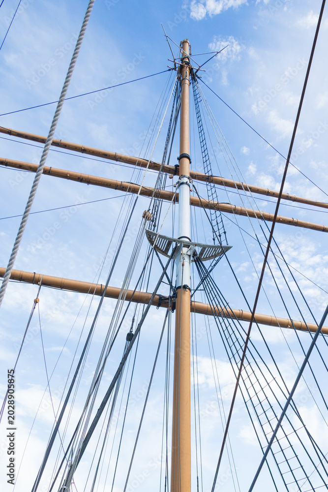 Obraz premium Sailboat Mast and ropes with cloudy blue sky background