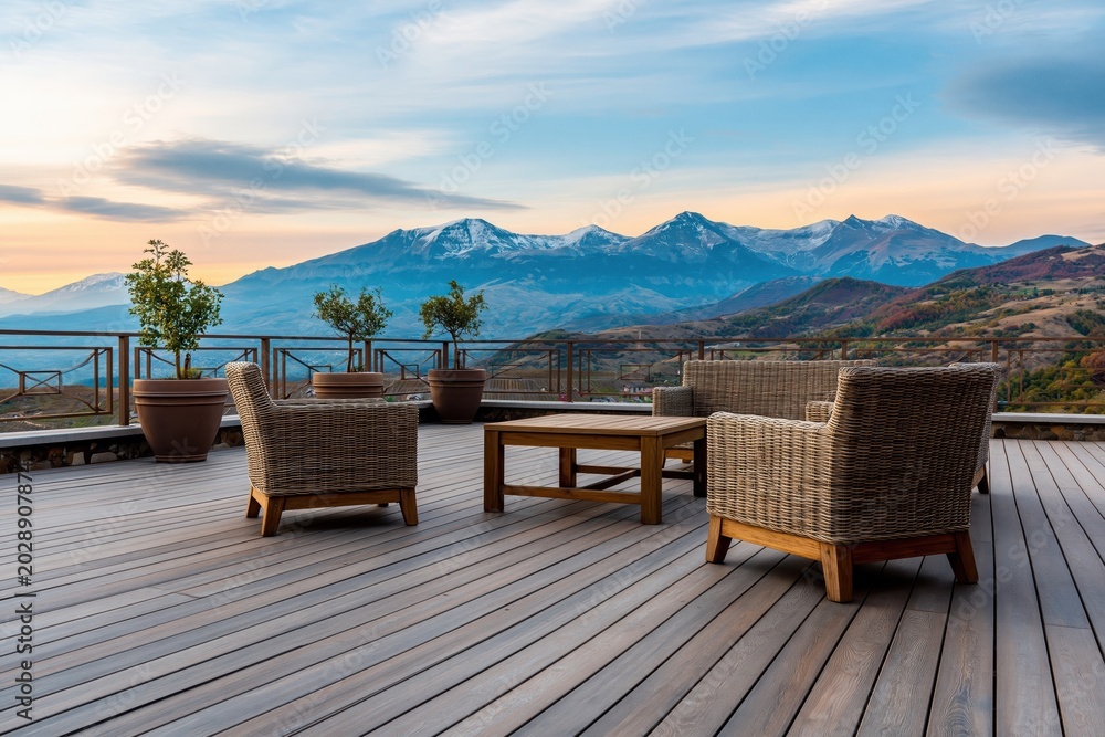 Naklejka premium Outdoor patio furniture set overlooking snow capped mountains