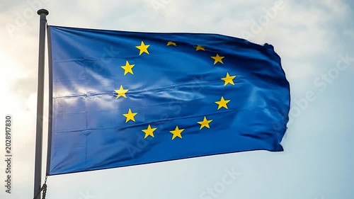A blue flag with a circle of yellow stars waving against a bright sky