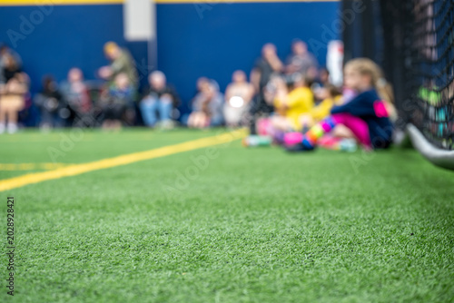 Children watch a sports event in an indoor field during a weekend afternoon