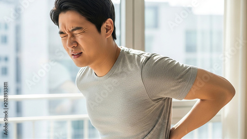 腰痛で腰を押さえる患者 整形外科と健康管理をイメージした医療コンセプト