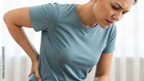 腰痛で腰を押さえる患者 整形外科と健康管理をイメージした医療コンセプト
