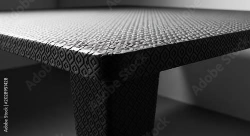 Macro shot of a black textured leather belt with a metal buckle showing design and material surface details on a grid background