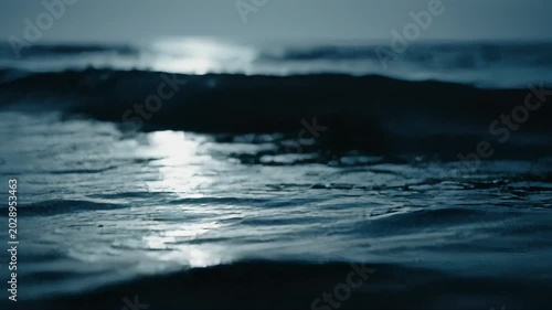Abstract view of choppy, dark blue water with bright highlights of light