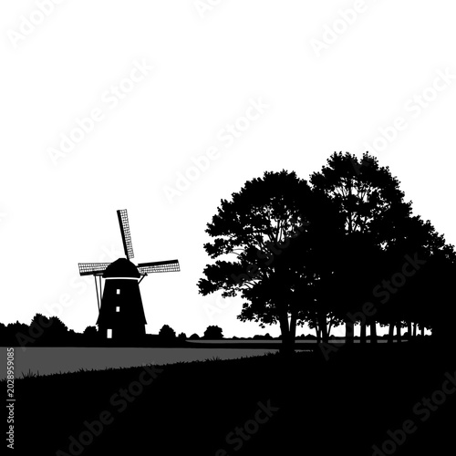 Silhouette of a historic Dutch windmill and trees against a white sky