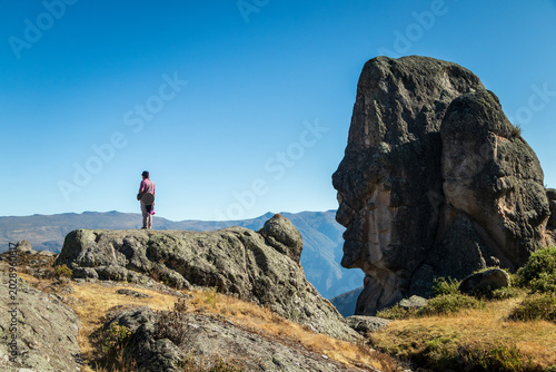 Tableau sur toile Traveler standing beside giant human face rock formation in Marcahuasi Andes Per