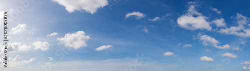 Wide angle panorama of beautiful sky with cumulus clouds  over a clear horizon.