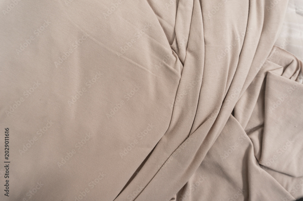 Obraz premium Smooth light brown fabric with soft folds and texture.