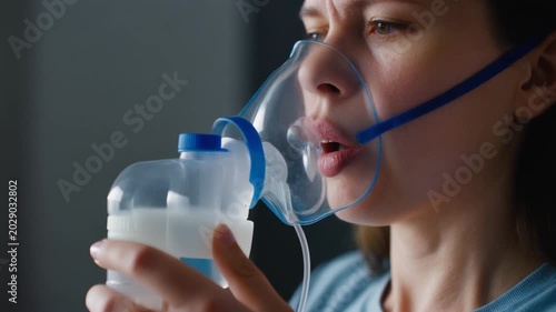 Woman using nebulizer for asthma treatment.