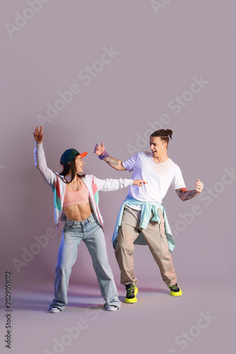 Tableau sur toile Couple of happy hip-hop dancers on color background